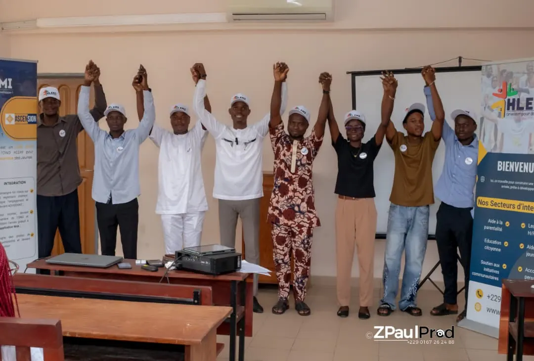 Membres de l'ONG HLEMI, bras levés, réunis lors d'une session de travail au Bénin